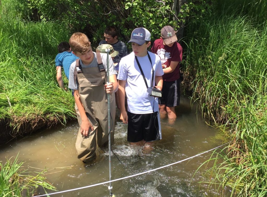 Students measure stream flow on Union Creek in Potomac.